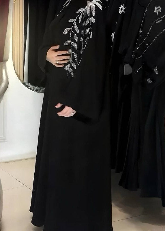 Black abaya with silver floral embroidery on a neutral background
